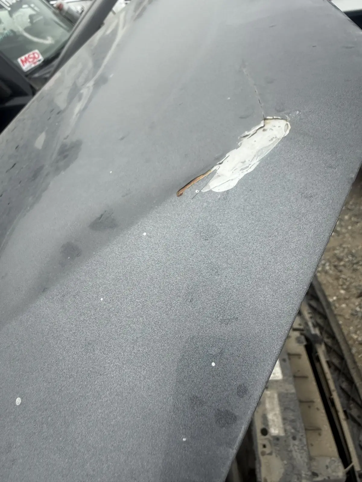 Filler under the paint, found on a used car check.