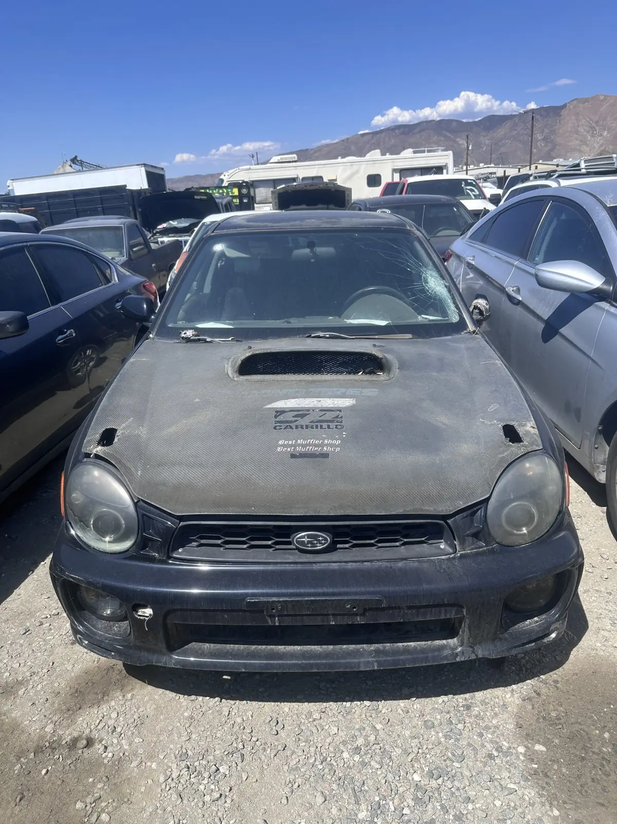 A Subaru waiting its turn, mountains behind it.